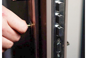 Male hand operates a key on a steel door